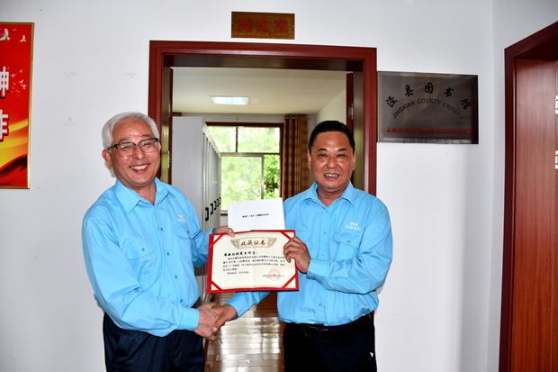 公司工會主席許鋒（右）向公司監(jiān)事會主席、捐書人胡夏生頒發(fā)《收藏證書》